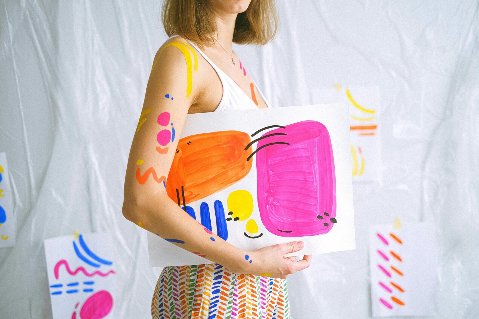 Vibrant body paint and abstract artwork in a creative indoor setting.