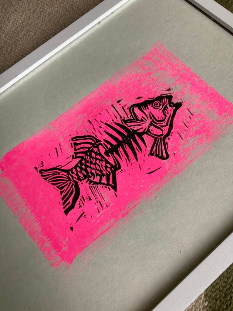 A5 Linoprint Black skeletal fish on fluorescent pink rectangle